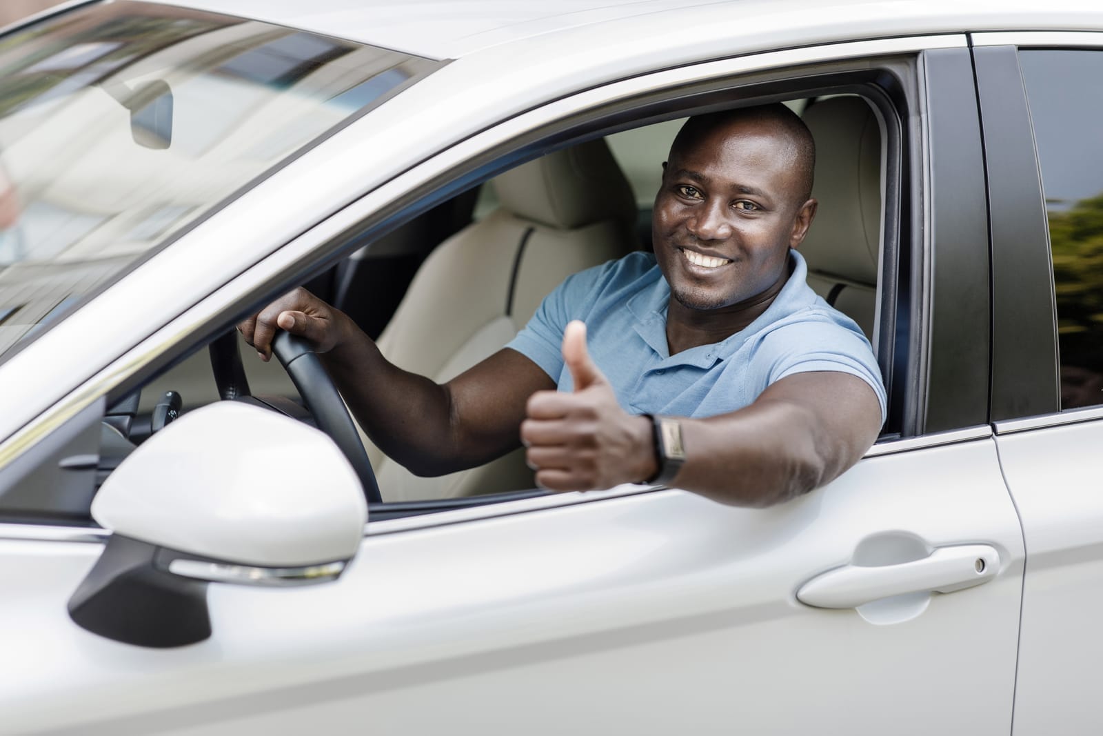 Smiling driver in a car after refinancing a logbook loan