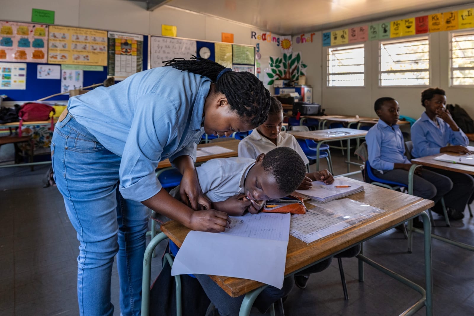 Teacher helping learners in a classroom