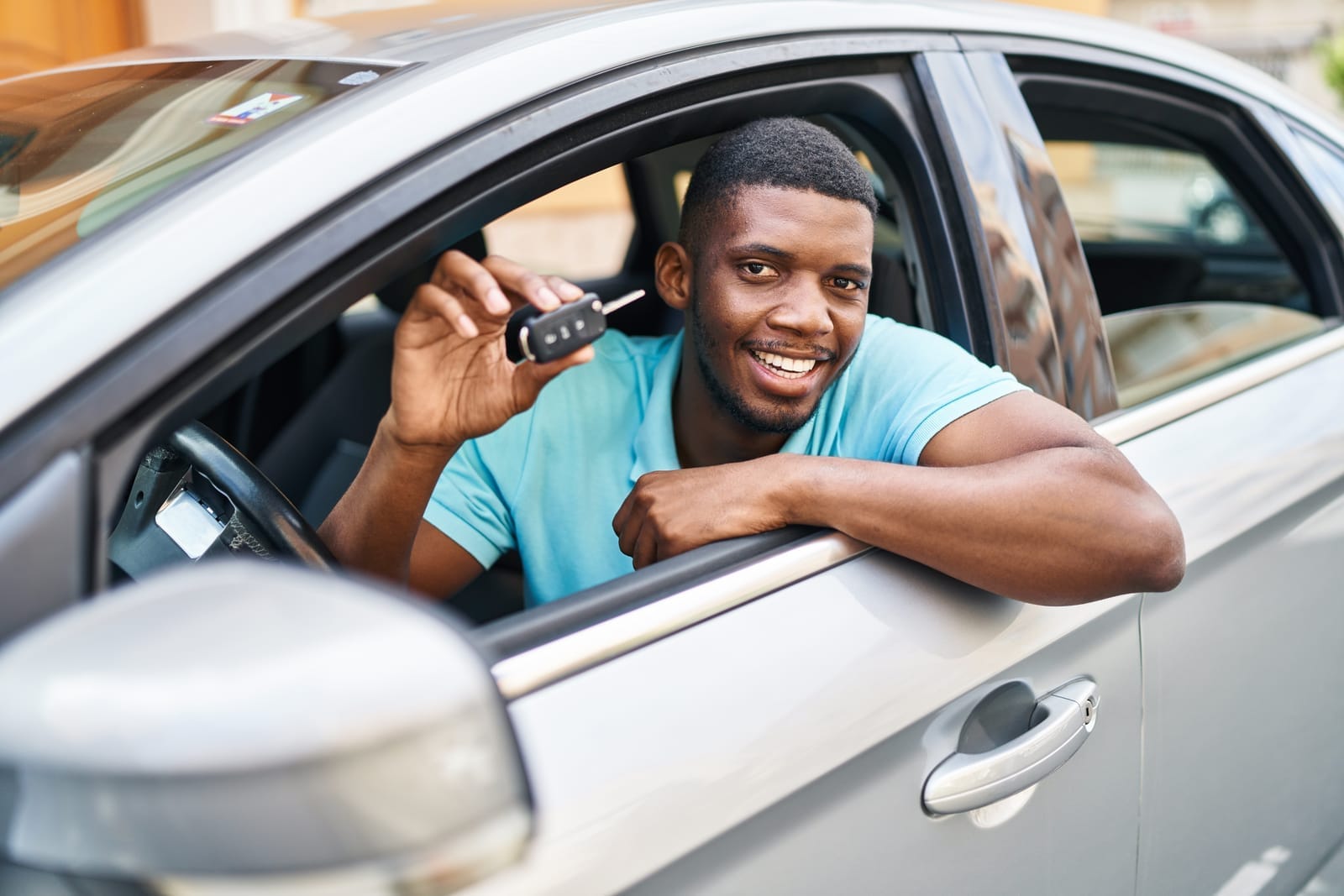 Smiling driver holding vehicle keys for a logbook loan